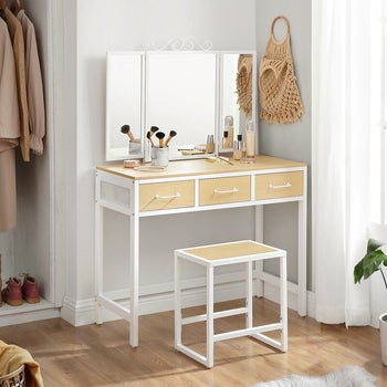 lifestyle photo of vanity set with mirror and stool, makeup onthe counter