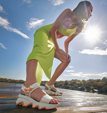 model wearing the sandals in white and orange