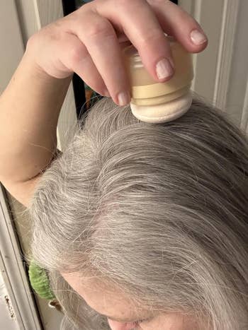 Person applying basal   touch-up pulverization  to grey  hairsbreadth  with a sponge applicator
