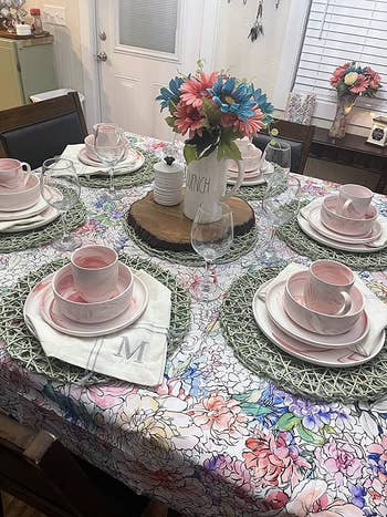 the swirly marble design pink and white plates, bowls, and mugs on a floral tablecloth