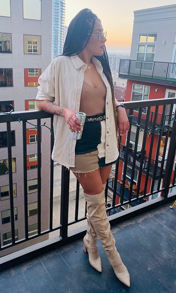 reviewer wearing it in beige with tank, denim skirt, and boots