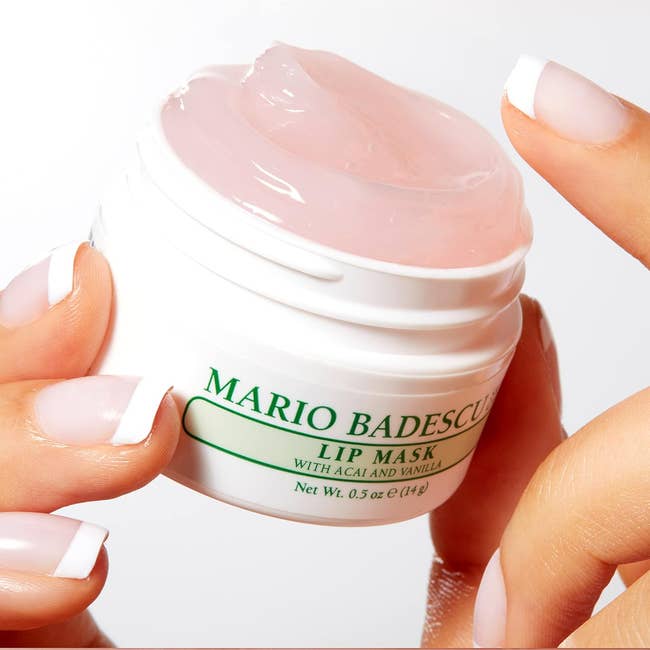 Hand holding Mario Badescu Lip Mask jar, manicured nails, product in focus for shopping content
