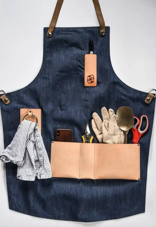 The apron is displayed with all the pockets filled with tools