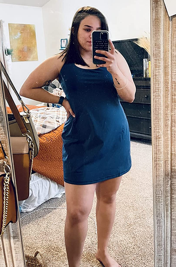 a reviewer wearing the sleeveless dress in navy blue 