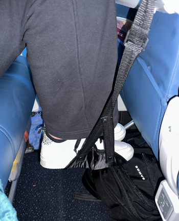 BuzzFeed writer using the foot hammock on an airplane