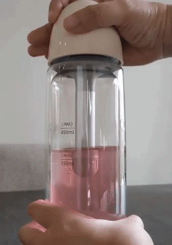 GIF of reviewer turning pink juice into a carbonated drink inside the portable sparkling water maker