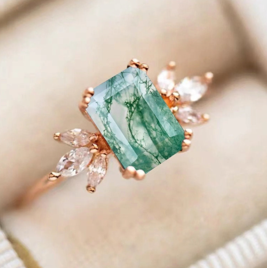 The rose gold band with a swirled green emerald cut moss agate ring and six diamonds