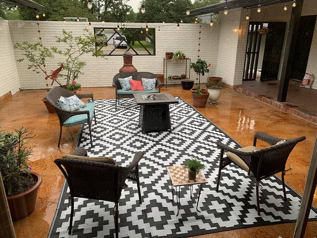 large rectangular rug with a dark gray and white geometric pattern on someone's patio
