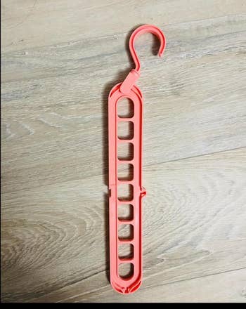 Clothes hanger with slots and a rotating hook, designed to maximize closet abstraction by hanging items vertically