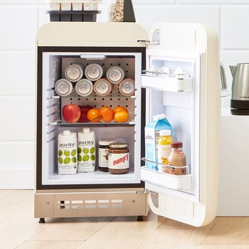 an open mini fridge full of food and beverages