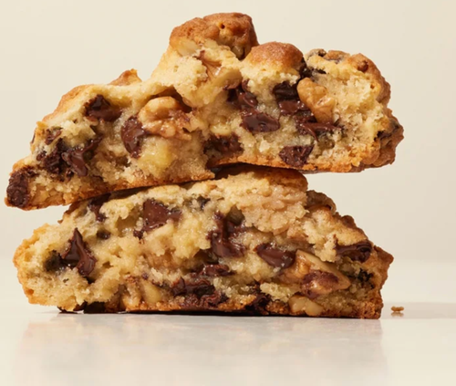 A cookie broken in half, showing the gooey inside and crunchy exterior 