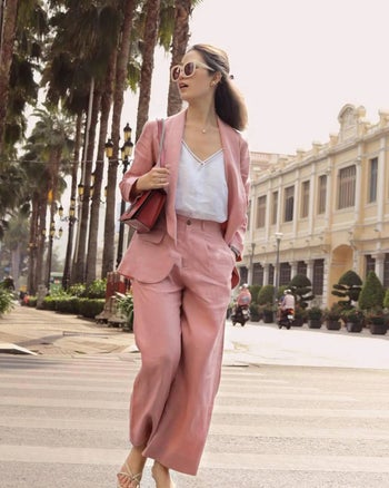full-length shot of model wearing the pink linen suit with a white top