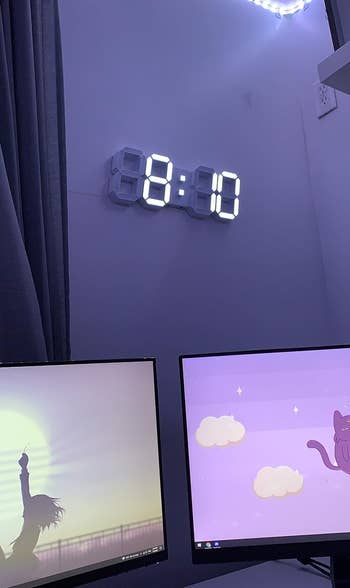 the digital clock hanging above monitors