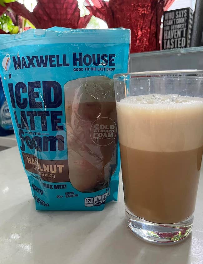 Maxwell House Iced Latte with Foam portion premix successful hazelnut spirit adjacent to a filled solid with foamy iced latte connected a countertop