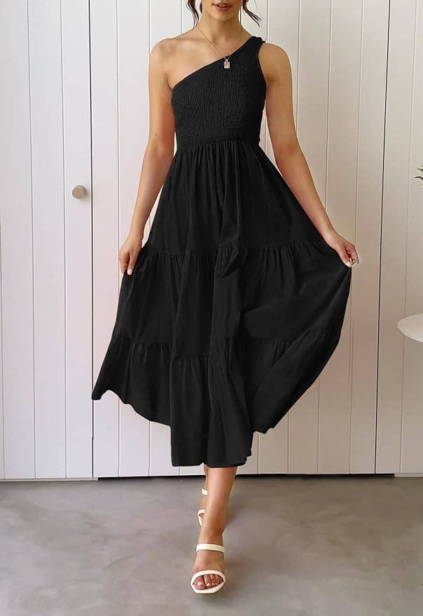 a model wearing the black, one shoulder dress with flowy skirt