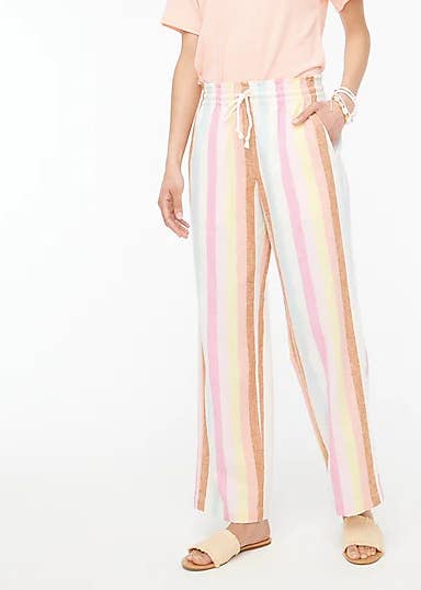 model in tan yellow peach pink white and light blue vertical stripe pants