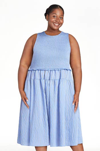 Smiling person wearing a sleeveless, textured midi dress suitable for warm weather, featured in a shopping article