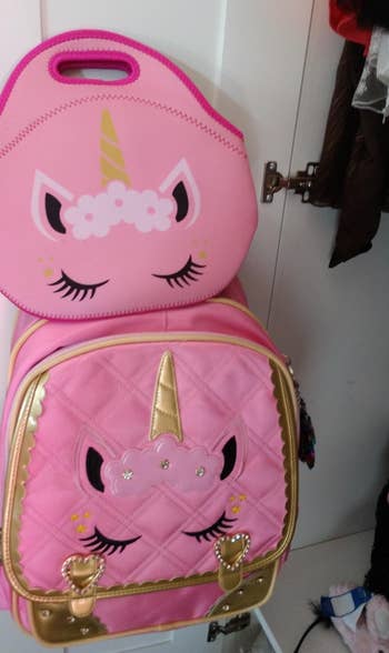 a reviewer's photo of the pink unicorn backpack and matching lunch box