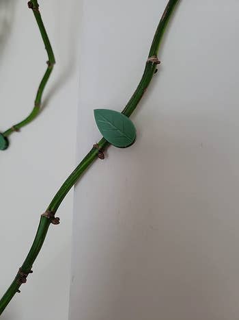 closeup of the green clip showing it's shaped like a tiny leaf and blends in with the green of the stem
