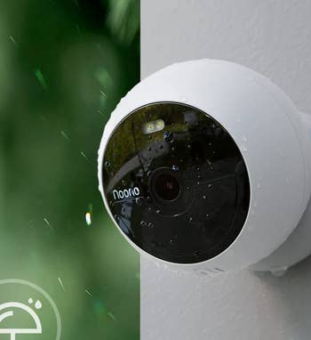 Small round white camera installed on a wall 