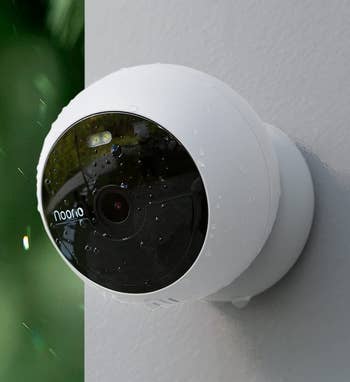 Small round white camera installed on a wall 