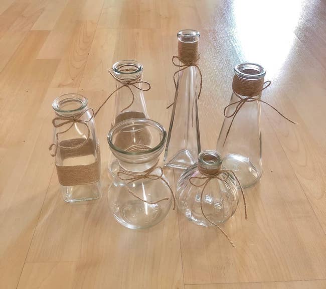 Reviewer image of six glass vases of various shapes and sizes on light wooden floor