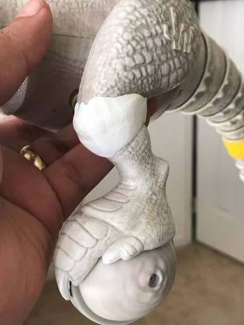 reviewer's toy plastic dinosaur whose knee was repaired with white sugru