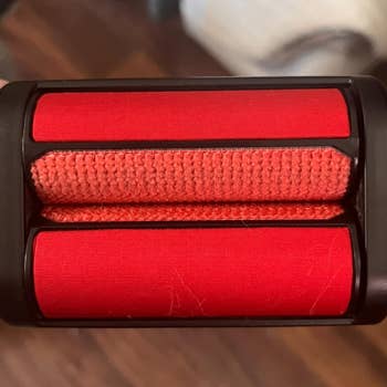 Close-up of adhesive lint remover roller with visible fabric and hair fibers