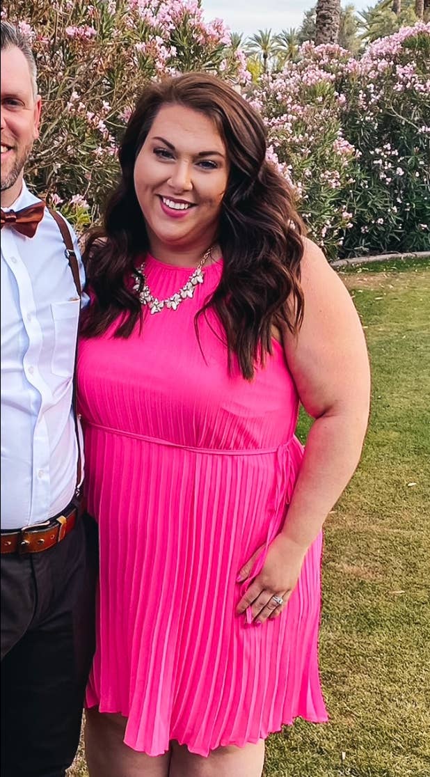 A reviewer wearing the dress in hot pink