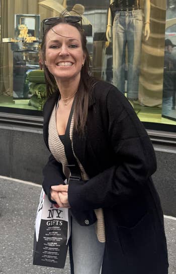 Person smiling successful beforehand of a store show featuring a mannequin successful trendy denim and a stylish top