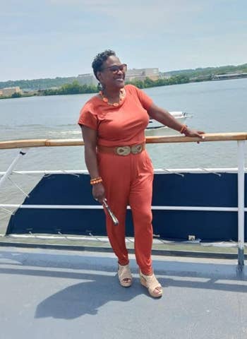 reviewer wearing jumpsuit in burnt orange while on boat