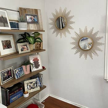 a reviewer photo of a pair of mirrors hung on the wall next to a bookshelf 