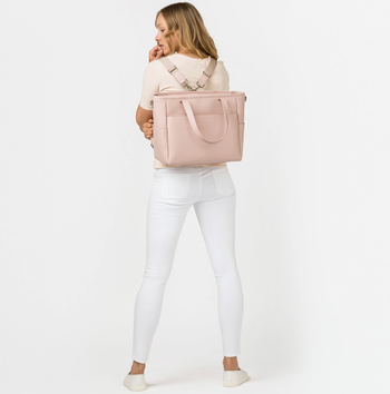 model using the peony colored tote as a backpack