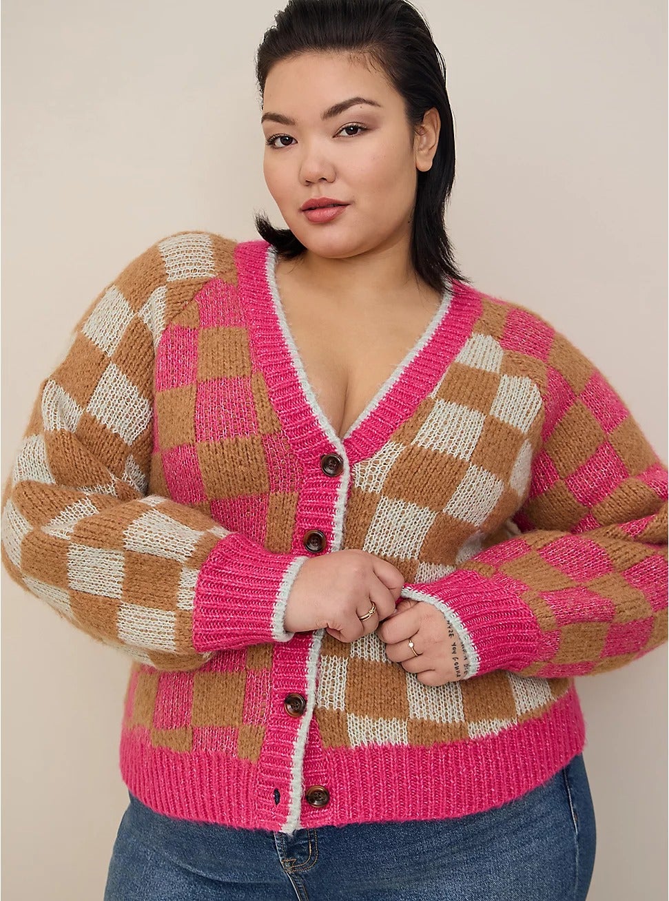 a model posing in the pink and brown checked sweater