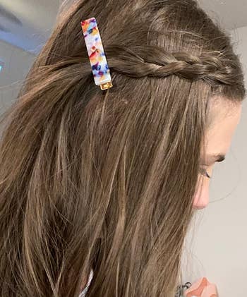 reviewer wearing a section of braided hair pulled back with a colorful barrette