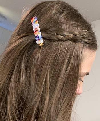 reviewer wearing a section of braided hair pulled back with a colorful barrette