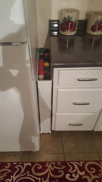 A reviewer photo of a slide out storage shelf in between their fridge and counter
