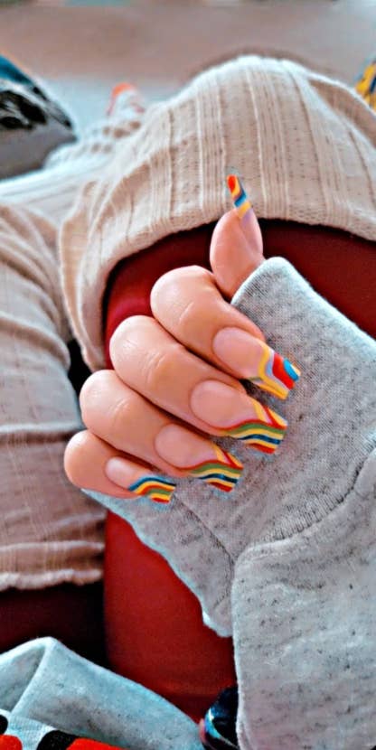 reviewer pic of wearing long rainbow abstract nails