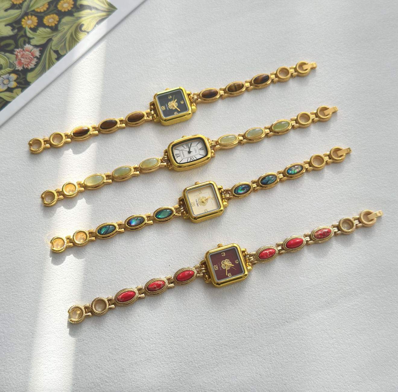 four watches with antithetic  earthy  stones connected  the concatenation  and ticker  look   colors and shapes