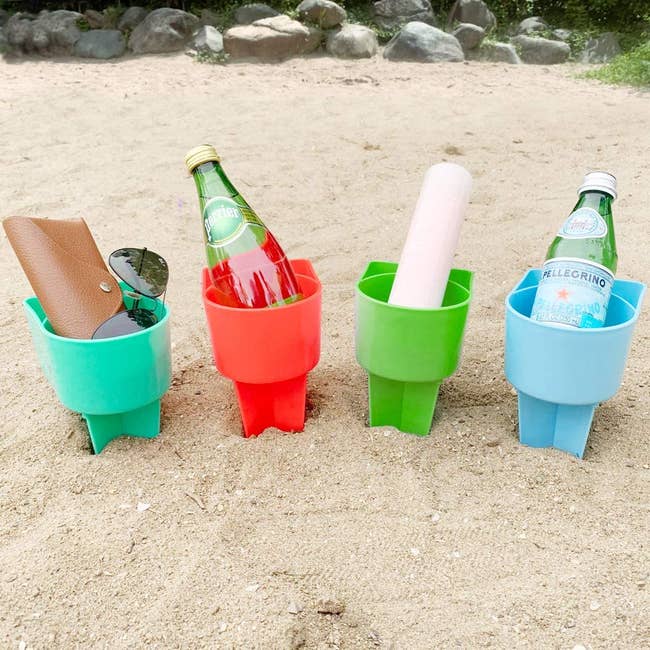 four plastic cup holders with drinks and accessories inside it