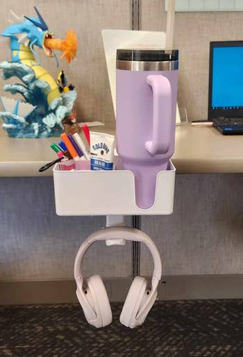 Desk accessories organizer with pens, lotion, a ample  mug, and headphones, perfect  for keeping workspace tidy
