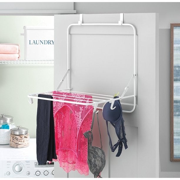 a door-mounted drying rack loaded up with bras and camisoles line drying