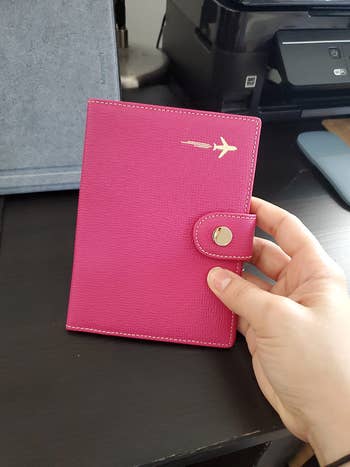 reviewer photo, front of pink leather passport holder with airplane logo