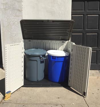 open shed to reveal a trash can and recycling bin 