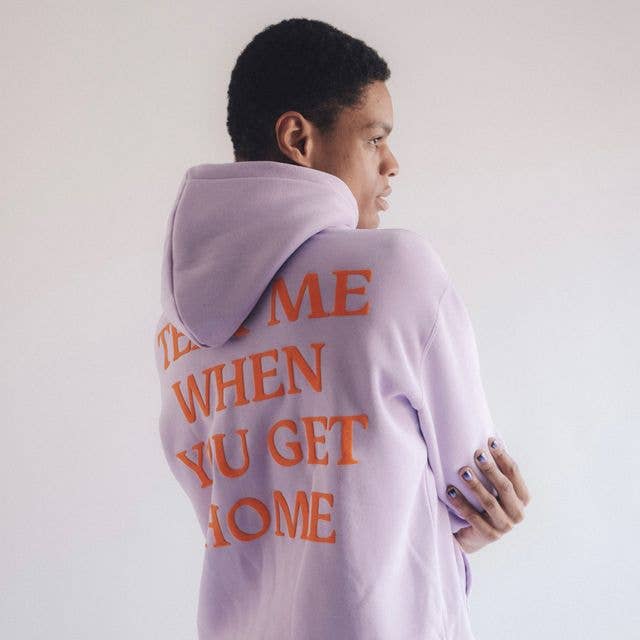 model wearing the hoodie in purple with orange text