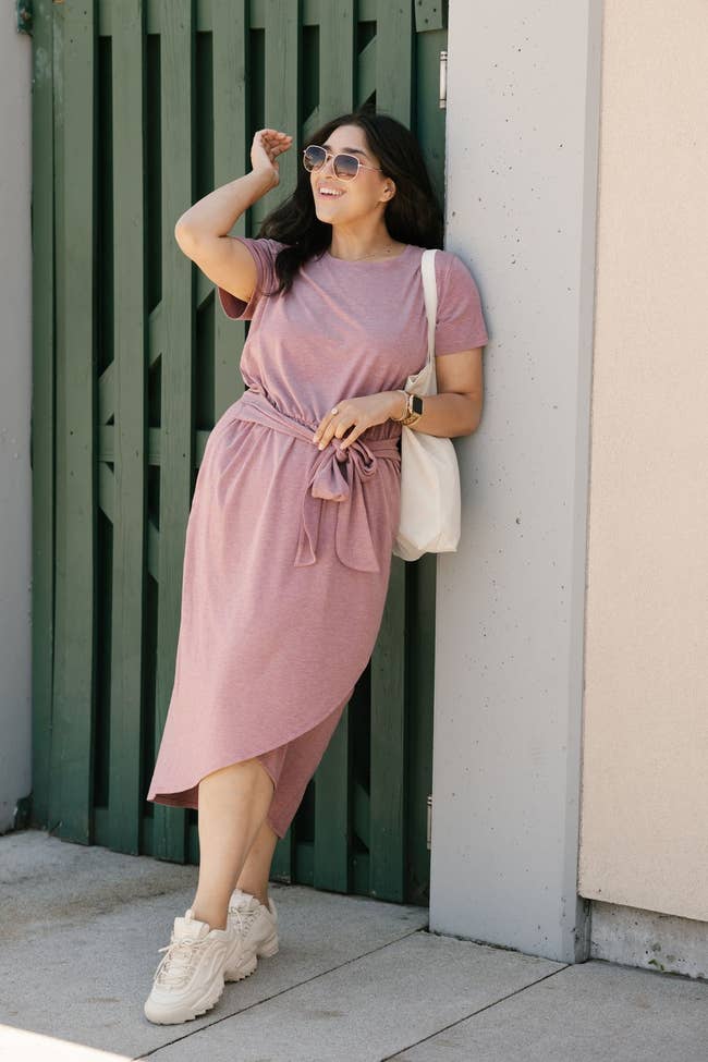 model wearing a dusty rose dress with white sneakers