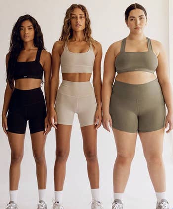 Three models basal   successful  diversion  deterioration  consisting of sports bras and shorts, showcasing antithetic  assemblage  types, promoting inclusive activewear