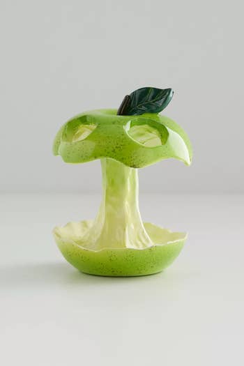 Ceramic fruit bowl designed to look like an apple core with a small green leaf. Suitable for kitchen decor or serving snacks