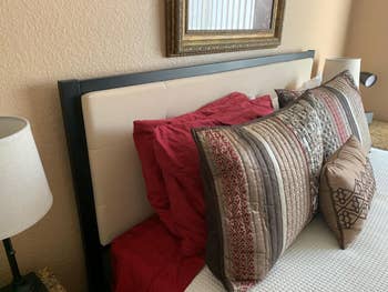 Reviewer image of side-view of product attached to bed with pillows along front