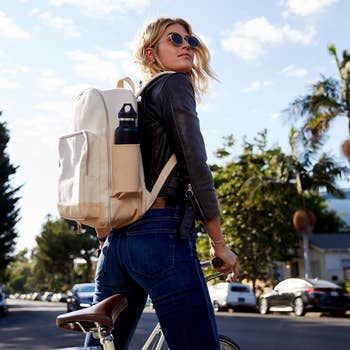 model wearing the nude backpack while on a bike